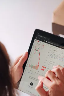 a woman holding a tablet with a chart on it by George Dagerotip courtesy of Unsplash.