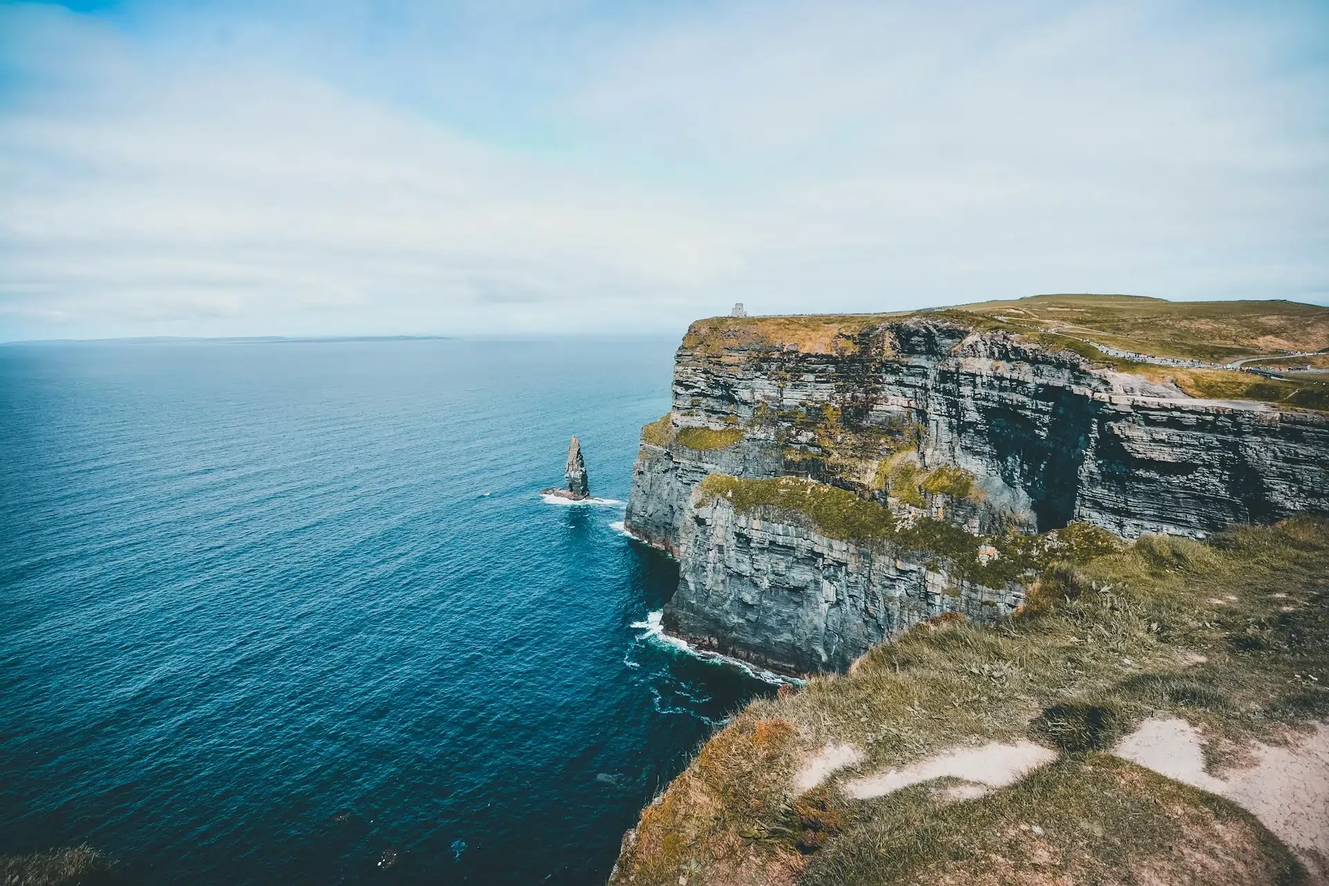 Majestic Cliffs of Moher in Ireland, showcasing dramatic sea cliffs and lush green landscapes under a clear blue sky.