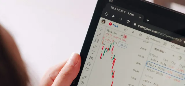 a woman holding a tablet with a chart on it by George Dagerotip courtesy of Unsplash.